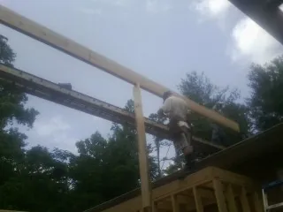 Carpenter setting a ridge beam over a new addition frame — Ice Dam Removal by Roofing Brothers in Filer