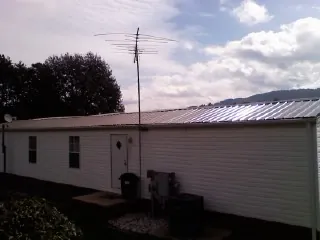 New metal roof on a single wide mobile home with a TV antenna in Filer