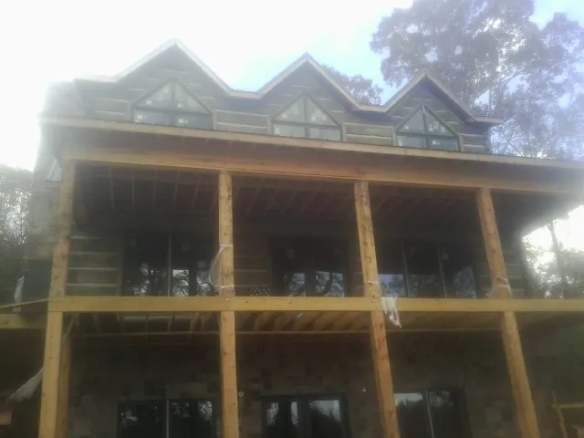 Dormers and porch framing on a large log home under construction — Roof Coating work by our crew in Filer