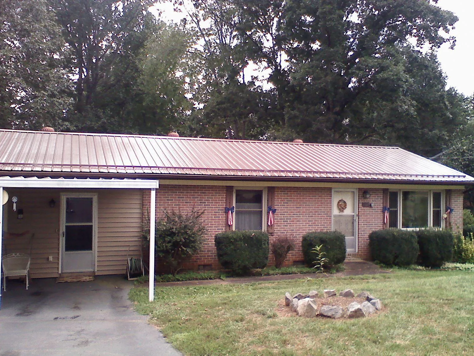 Bronze metal roof and carport on a brick ranch home — Roof Repair work by our crew in Filer